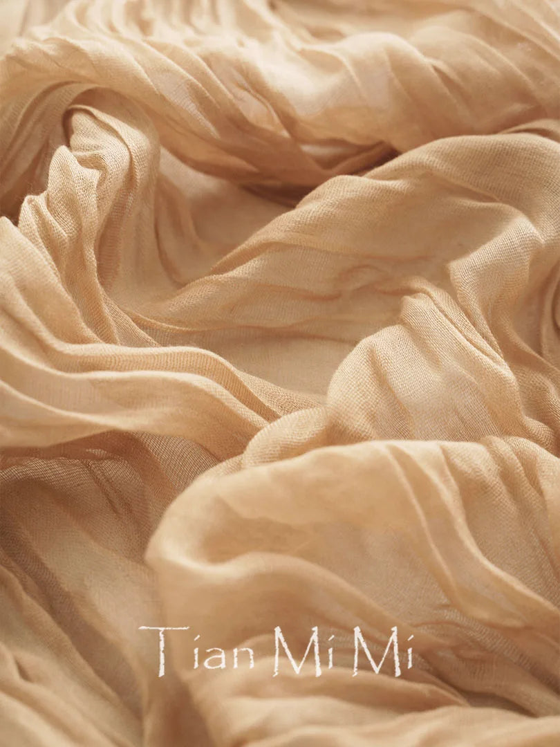 Texture élégante et enveloppante d'un tissu beige fluide, avec l'inscription "Tian Mi Mi" qui confère une touche de raffinement.