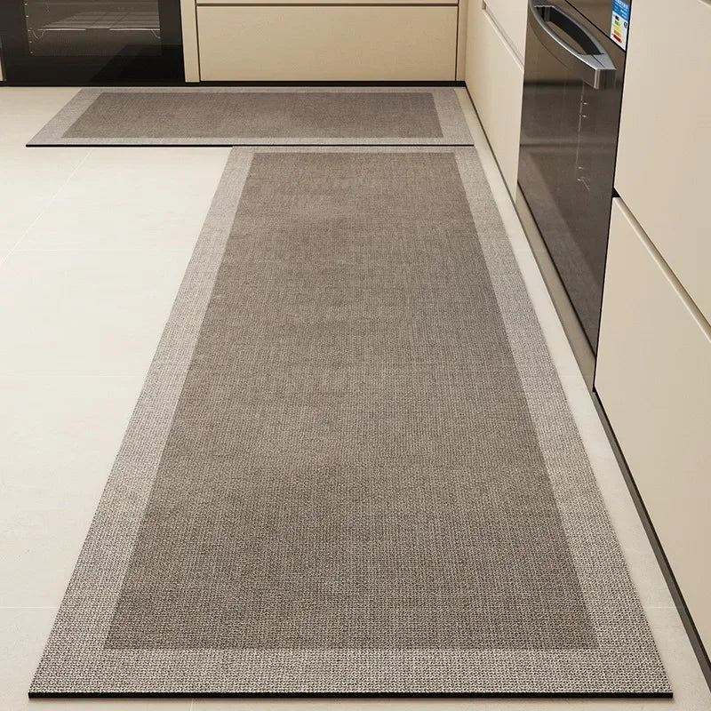Un tapis gris étroit et allongé, posé sur un sol blanc, qui semble être installé dans une cuisine.