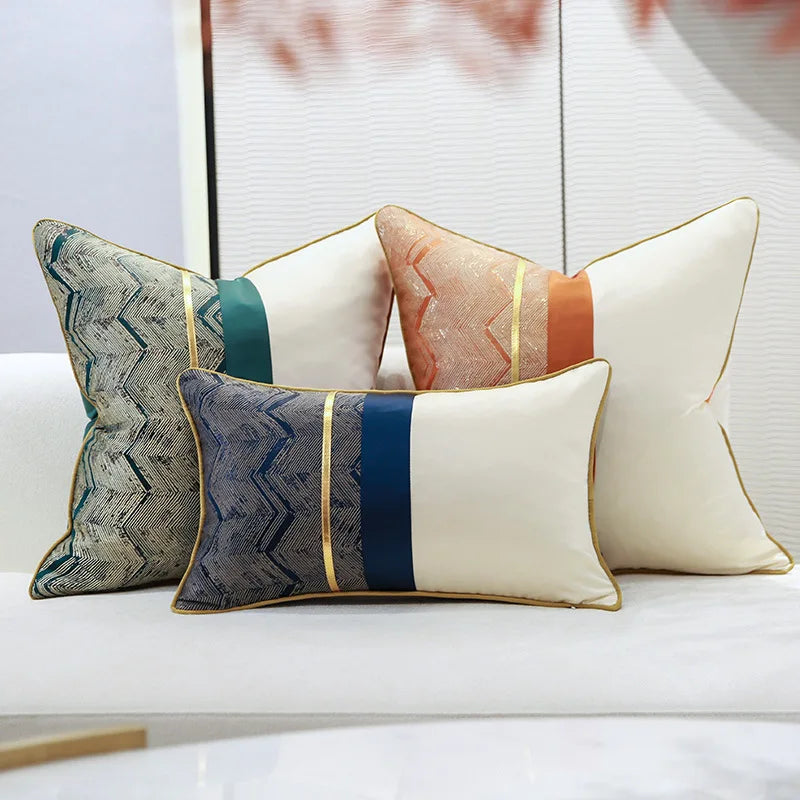 Superbes coussins décoratifs aux couleurs chaudes et douces, avec des motifs géométriques élégants et des bandes dorées qui apportent une touche de sophistication.