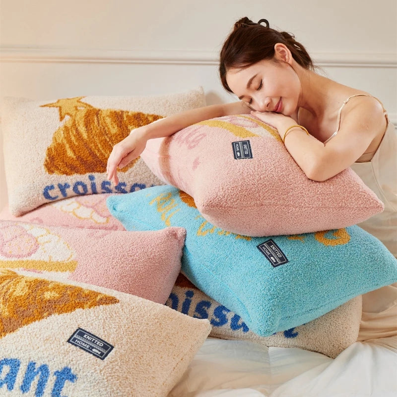 Une femme aux yeux fermés repose confortablement sur des coussins colorés et moelleux dans une ambiance apaisante.