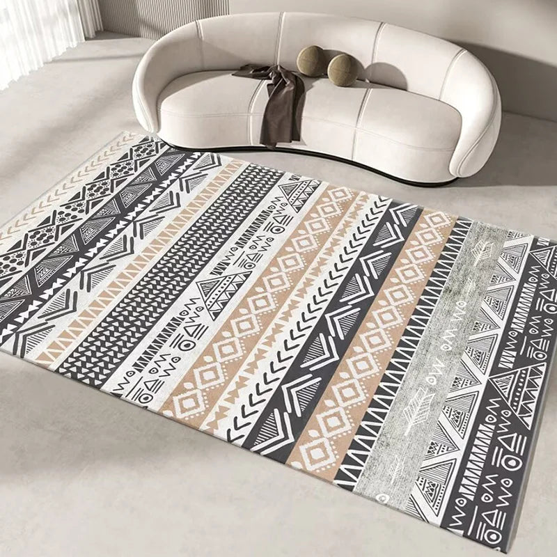 Tapis ethnique noir et beige avec des motifs géométriques complexes sur le sol devant un canapé blanc.