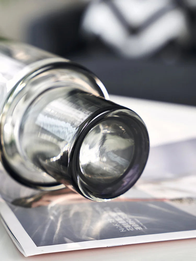 Un gros plan sur un bocal en verre transparent posé sur des documents.