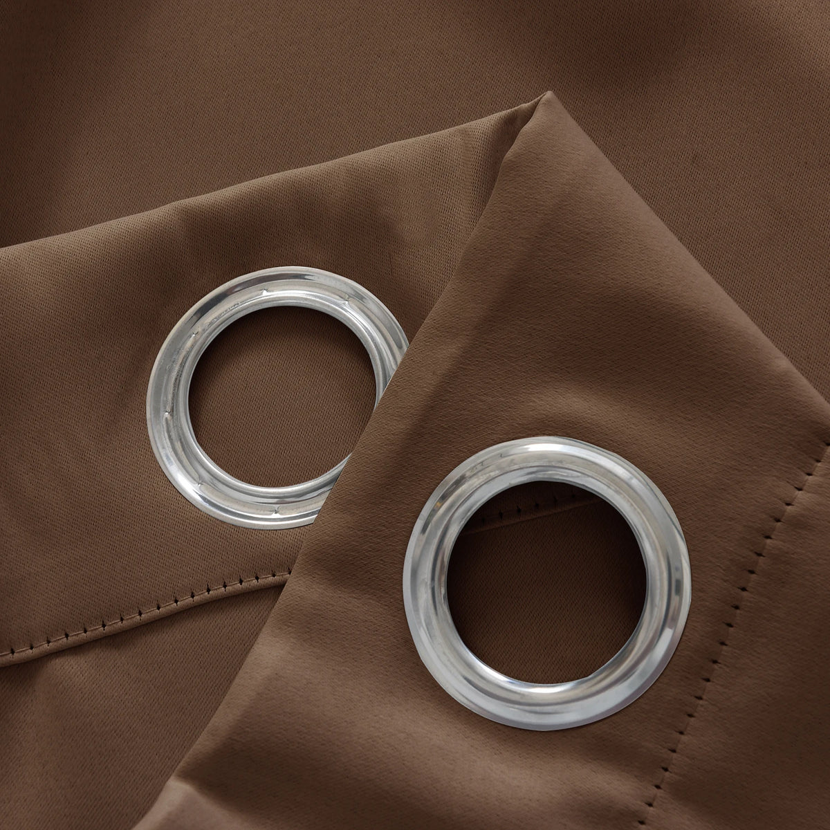 Image illustrant des rideaux de haute qualité avec des grommets en métal, suspendus élégamment dans un salon contemporain. Ces rideaux, de couleur neutre, sont faits de matériaux durables et ajoutent une touche de sophistication et de modernité à n'importe quel espace de vie. Utilisez des rideaux à œillets pour un look élégant et une facilité d'utilisation exceptionnelle.