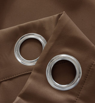 Image illustrant des rideaux de haute qualité avec des grommets en métal, suspendus élégamment dans un salon contemporain. Ces rideaux, de couleur neutre, sont faits de matériaux durables et ajoutent une touche de sophistication et de modernité à n'importe quel espace de vie. Utilisez des rideaux à œillets pour un look élégant et une facilité d'utilisation exceptionnelle.