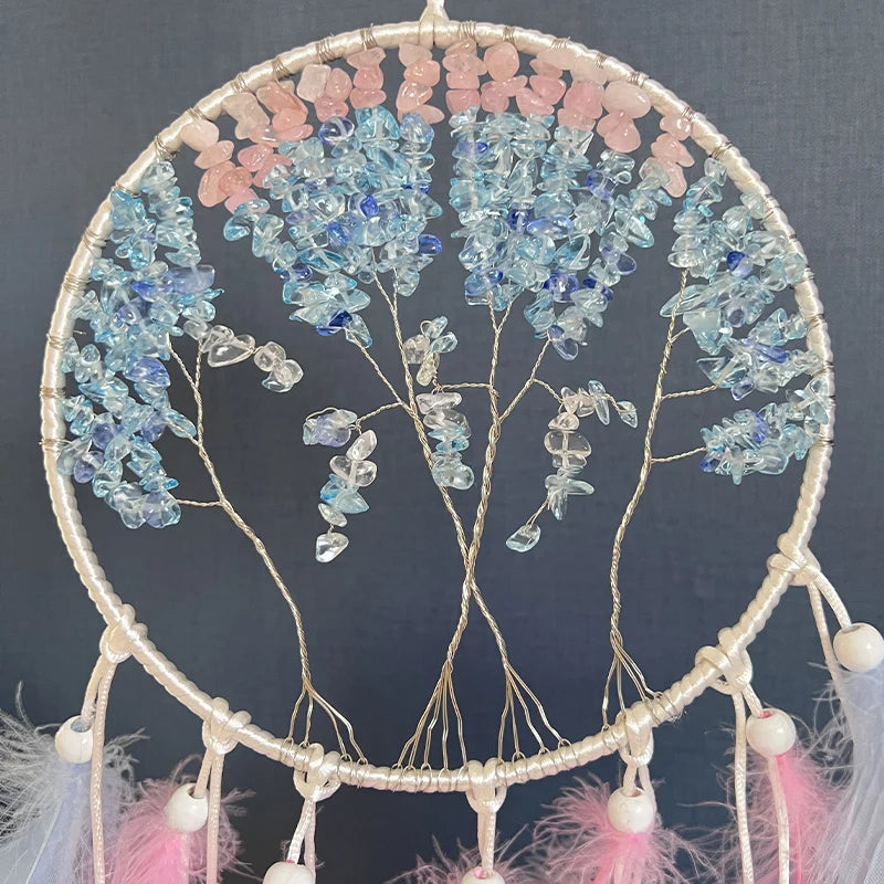 Une couronne de rêve sculptée en fil de cuivre ornée de pierres précieuses de différentes teintes de bleu et de rose, suspendue dans un cadre en forme de cercle.