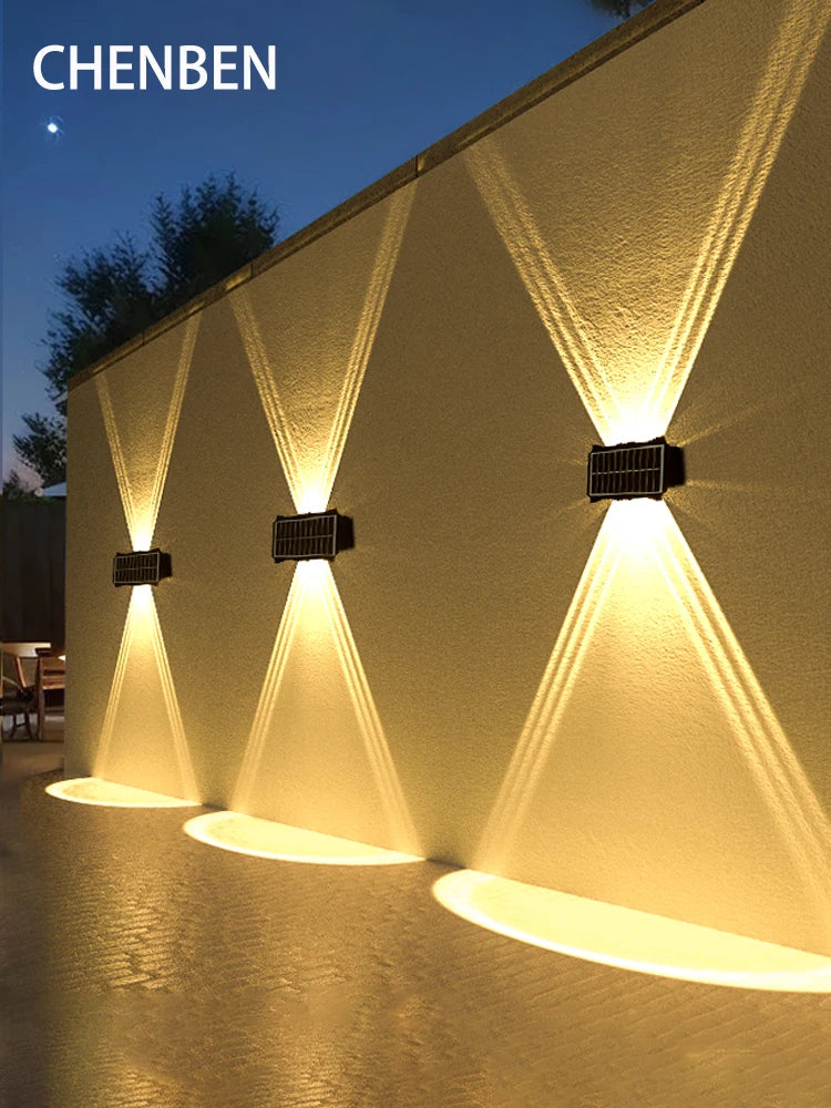 Applique murale solaire LED noire éclairant un jardin la nuit