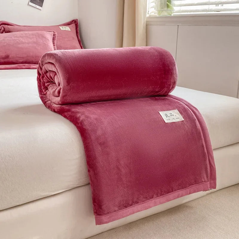 Une couverture en velours rose foncé posée sur un lit dans une chambre à coucher, offrant un look confortable et douillet.