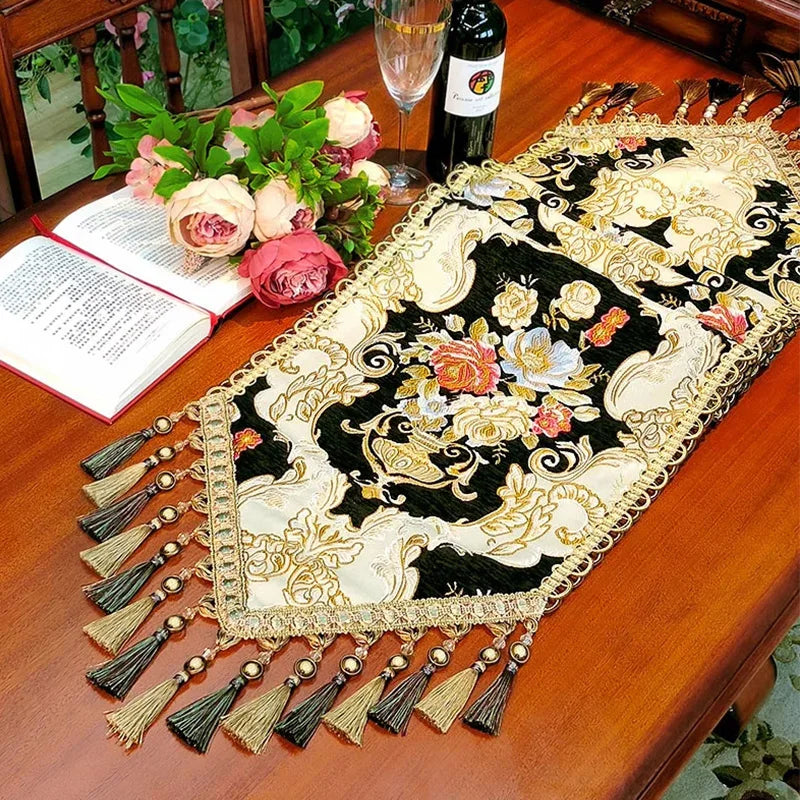 Un élégant chemin de table décoré de magnifiques fleurs et d'un motif doré et noir captivant, créant une ambiance chaleureuse et raffinée.