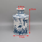 Vase décoratif en porcelaine bleu et blanc orné de motifs floraux et d'oiseaux exotiques, mesurant 25 cm de hauteur et 17 cm de largeur.