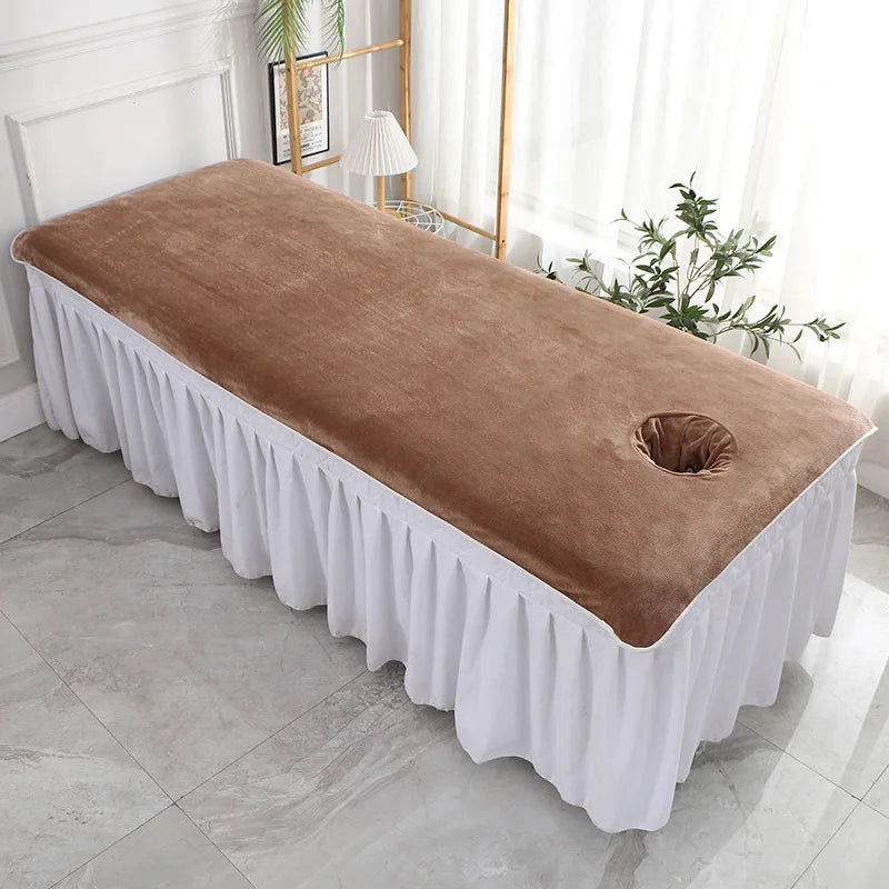 Couverture de table de massage en cuir brun clair avec jupe blanche dans une salle de massage spacieuse et lumineuse.
