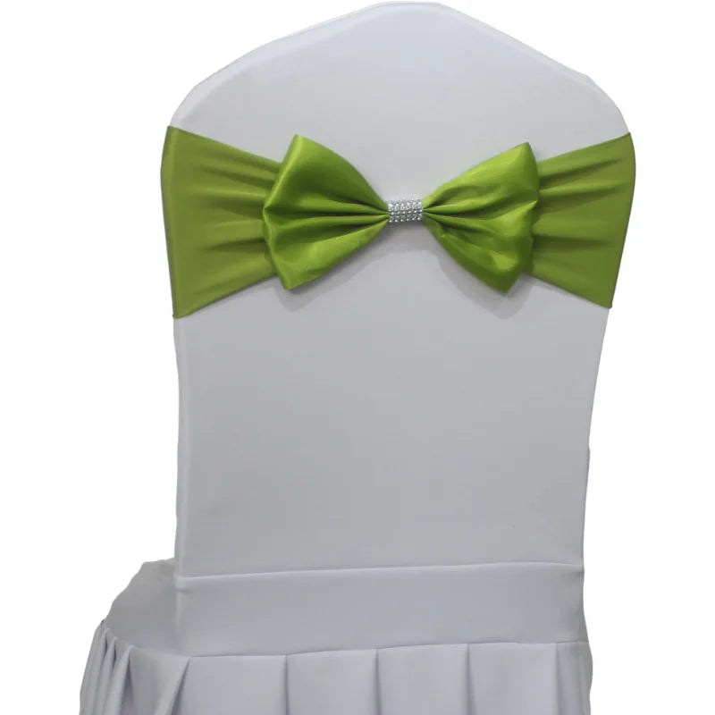 Une chaise blanche avec un nœud papillon vert orné de strass.