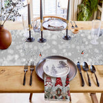 Une élégante table de fête hivernale avec des décorations festives, des assiettes avec un motif de paysage enneigé et des chandelles sur un fond de lumière scintillante.