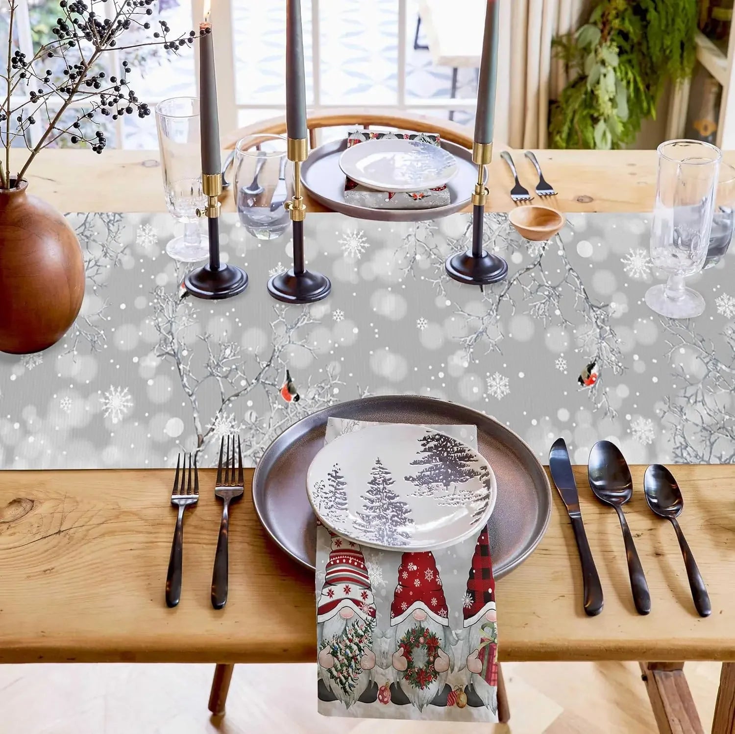 Une élégante table de fête hivernale avec des décorations festives, des assiettes avec un motif de paysage enneigé et des chandelles sur un fond de lumière scintillante.