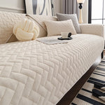 Une chambre aux tons neutres avec un canapé moelleux et des coussins coordonnés, créant une atmosphère paisible et relaxante.