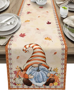 Le chemin de table affiche des motifs automnaux, notamment des feuilles colorées et un petit gnome portant un chapeau rayé, dans une scène de nature paisible.