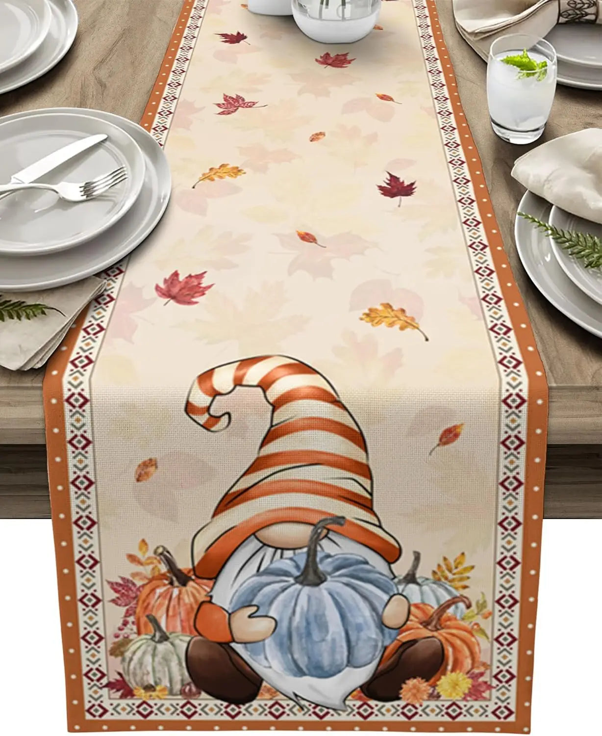 Le chemin de table affiche des motifs automnaux, notamment des feuilles colorées et un petit gnome portant un chapeau rayé, dans une scène de nature paisible.