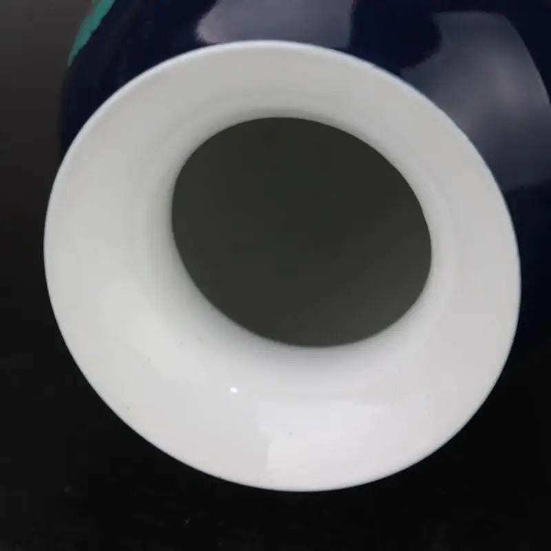 Un récipient blanc de forme cylindrique contenant un disque noir au centre.