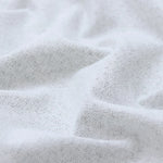 Gros plan du tissu blanc texturé du rideau isolant thermique, illustrant la qualité de son tissage.