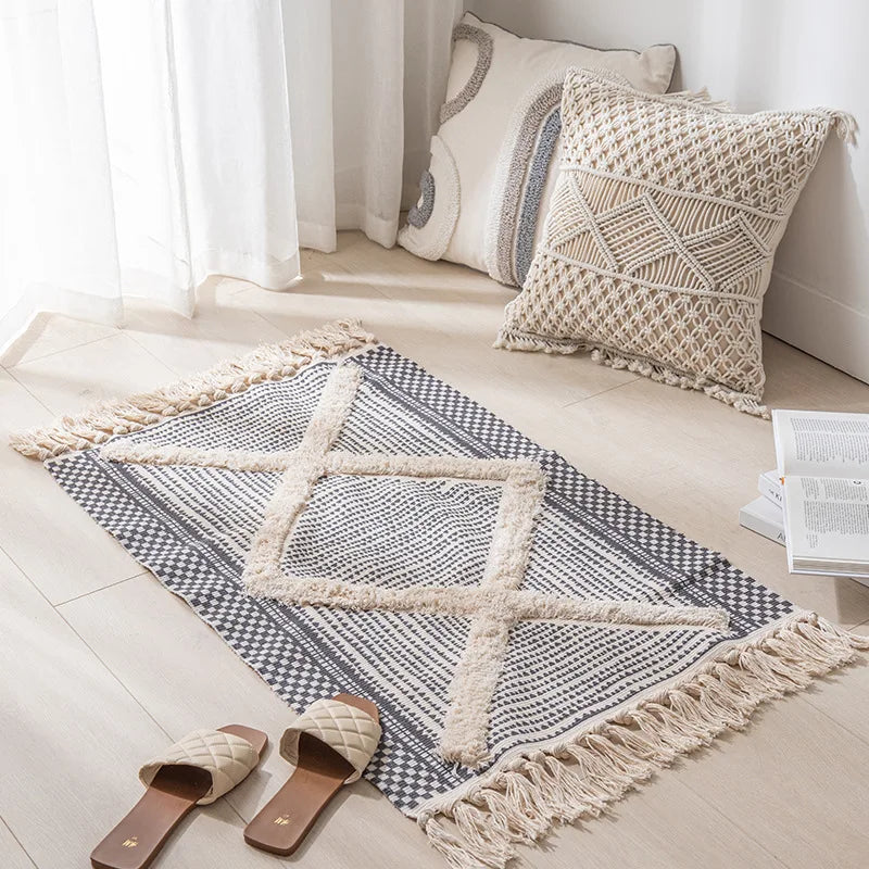 Un tapis de sol en coton et fibre naturelle dans des tons beiges et gris, avec un motif géométrique élégant, placé dans un intérieur lumineux et épuré.