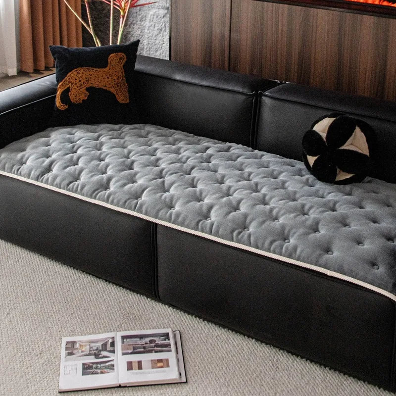Le lit en cuir noir avec un matelas en peluche grise et des coussins décoratifs crée une ambiance confortable et douillette dans cette pièce.