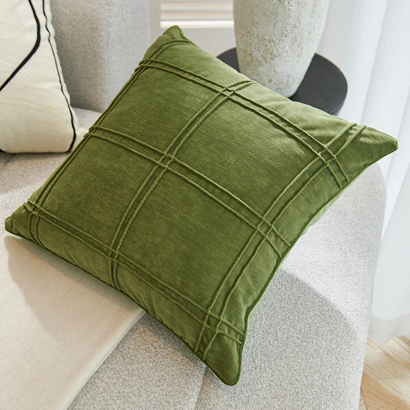 Coussin décoratif vert olive avec une conception géométrique de lignes en croisillons.