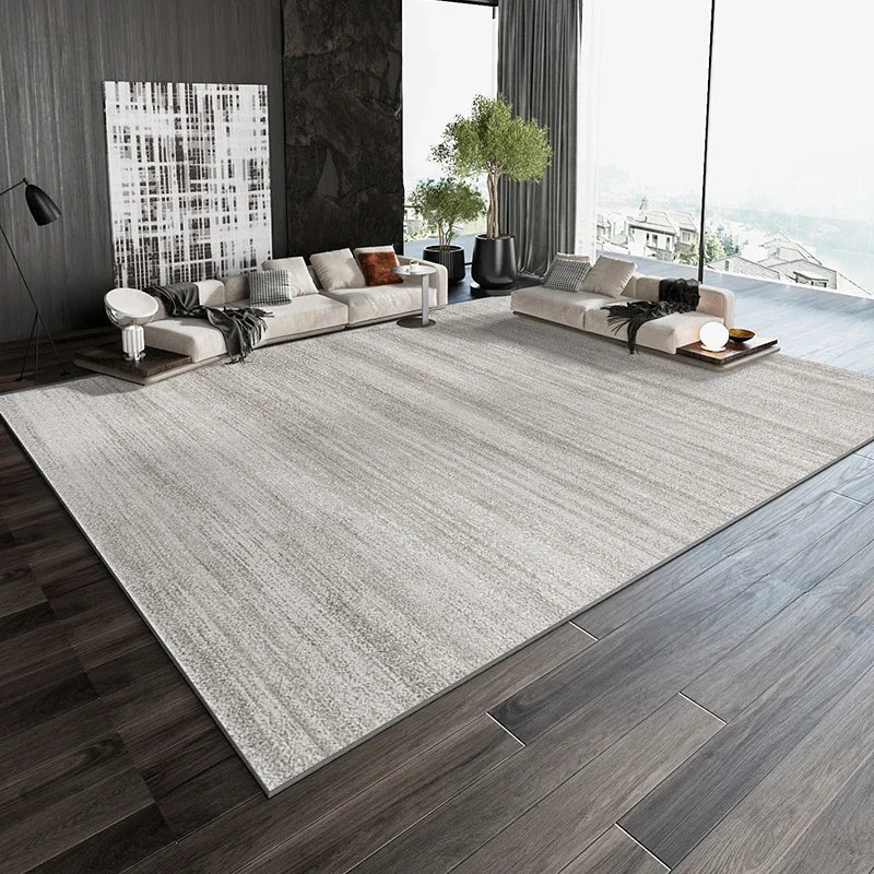 Intérieur d'un salon moderne avec des canapés confortables, des éléments décoratifs et des fenêtres offrant une vue imprenable sur le paysage extérieur.