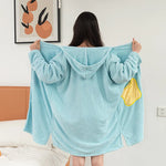 Une jeune femme porte un sweat à capuche bleu clair avec un design tendance.