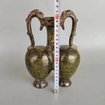 Deux vases décoratifs de forme ovoïde, avec des anses en forme de têtes d'animaux, recouverts d'un vernis craquelé aux teintes dorées et verdâtres.