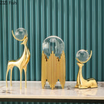 statues cerfs dorées boule cristal moderne décoration vase fleurs artificielles tableau noir