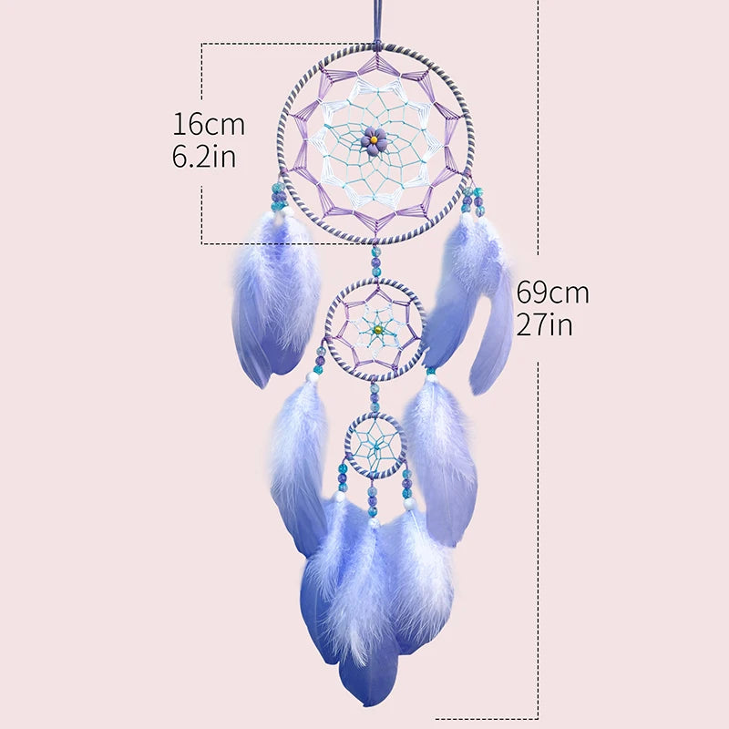 Un capteur de rêves aux motifs géométriques et plumes bleu clair, suspendu par un fil.