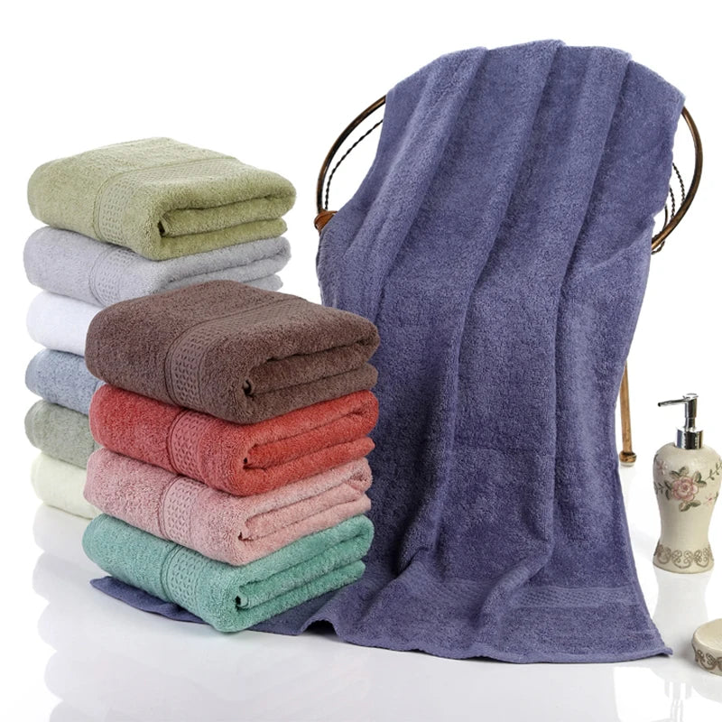 Grande serviette de bain 100% coton 70x140 cm épaisse et absorbante pliée sur un porte-serviettes en bois