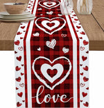 Chemin de table rouge à carreaux avec des coeurs blancs et le mot "Amour" au centre, créant une ambiance romantique et festive.