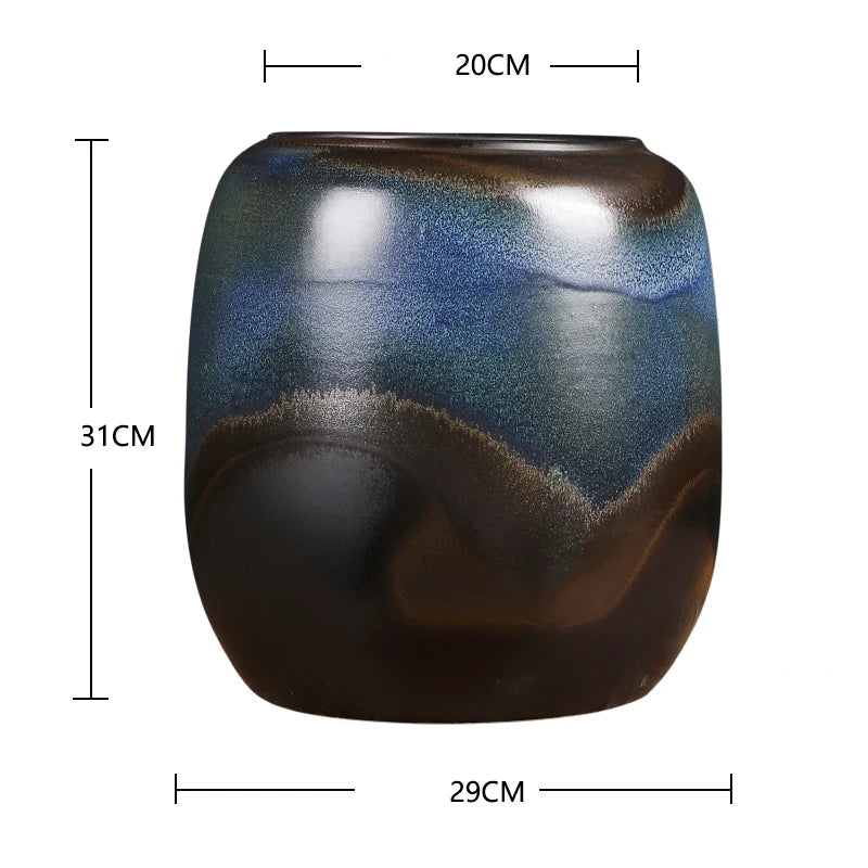 Vase en céramique de forme arrondie avec des motifs bleus et marrons sur un fond sombre.