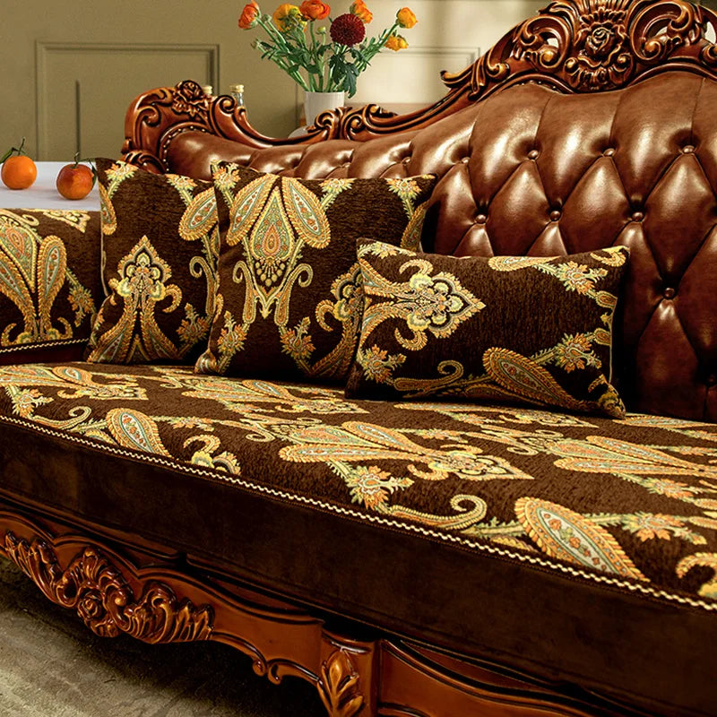 Ce canapé en cuir brun foncé avec des motifs dorés et des coussins à imprimé floral apporte une touche de luxe et d'élégance à la pièce.