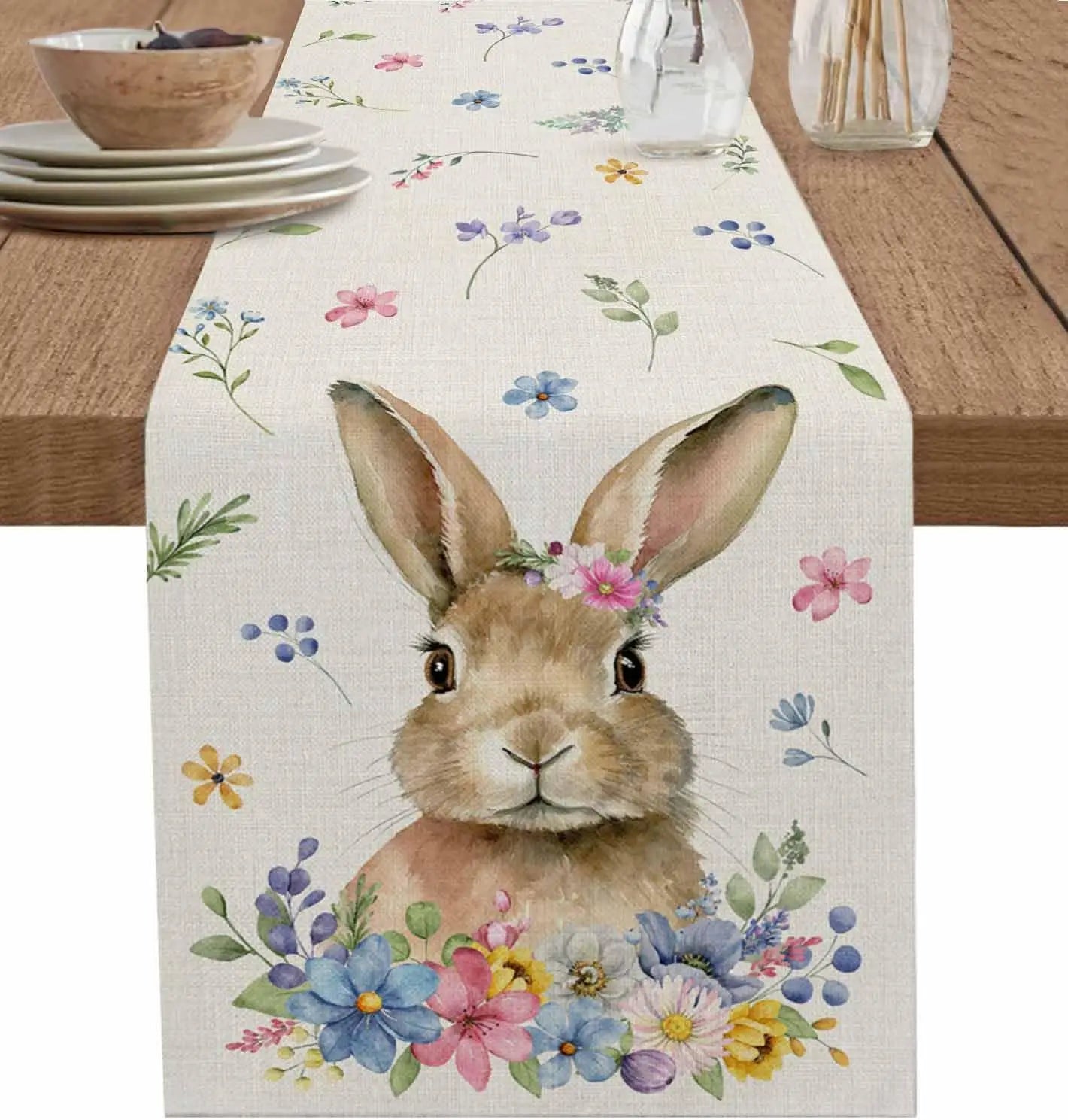 Une élégante table de salle à manger avec un chemin de table décoré d'un lapin mignon entouré de jolies fleurs colorées.
