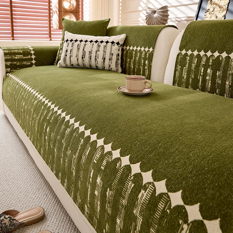 Un canapé douillet en tissu vert olive avec des motifs géométriques dans un intérieur chaleureux et lumineux, accompagné d'accessoires décoratifs harmonieux.