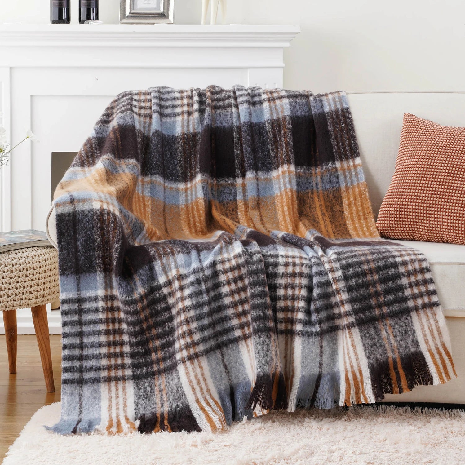 Une couverture en laine à carreaux gris, orange et blancs, parfaite pour une décoration cosy et confortable.