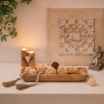 plateau décoratif bois marron clair boules fibres naturelles bougies translucides guirlande tassels fleurs artificielles
