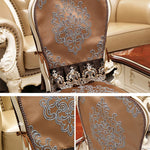 L'image montre un fauteuil vintage orné de motifs floraux brodés de couleur beige sur le dossier et les accoudoirs, créant un design décoratif élégant.