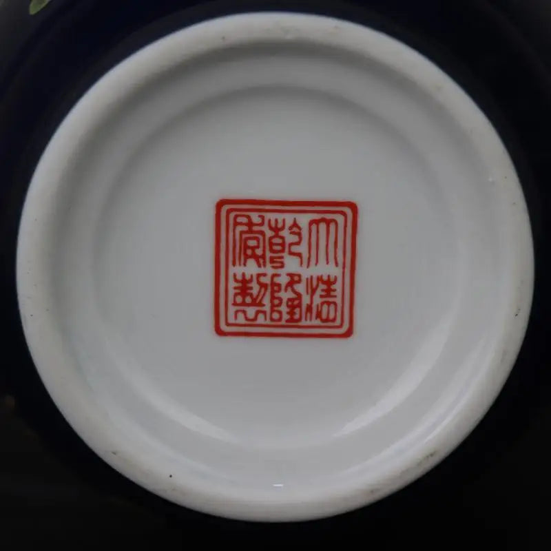L'image montre un plat en céramique blanche avec un sceau imprimé en rouge contenant des caractères chinois.