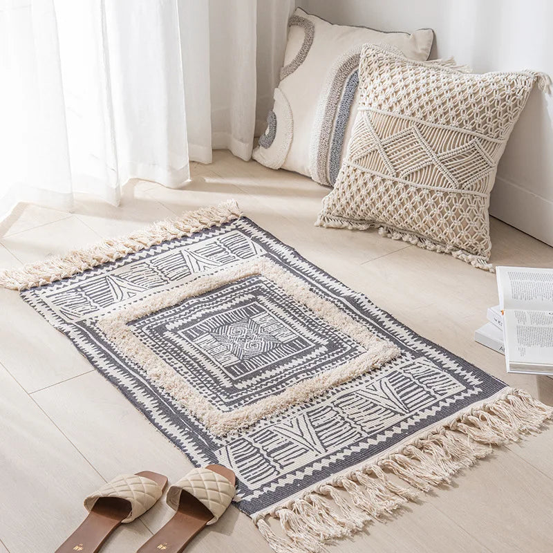 Tapis et coussins décoratifs avec motifs géométriques ethniques dans un intérieur lumineux et minimaliste.