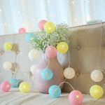 Installation de la guirlande lumineuse boules de coton sur une terrasse