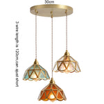 suspension lumineuse verre teinté art deco or marron bleu clair motifs géométriques opacité chaînes