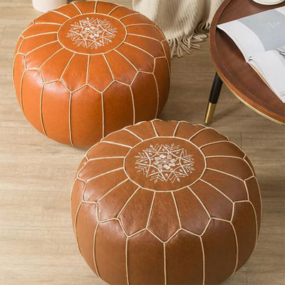 Pouf marocain rond en cuir véritable blanc sur un sol en bois
