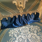 Un rideau en velours bleu foncé orné de broderies dorées et de motifs floraux décoratifs, créant une atmosphère luxueuse et élégante.