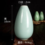 Vase décoratif en céramique de couleur vert clair aux dimensions de 10 cm de hauteur et 6 cm de largeur.