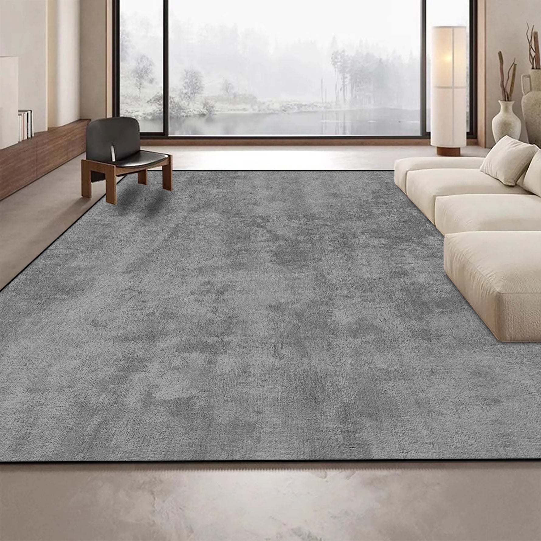 Un tapis gris sobre et contemporain complète harmonieusement ce salon moderne et lumineux aux larges baies vitrées.