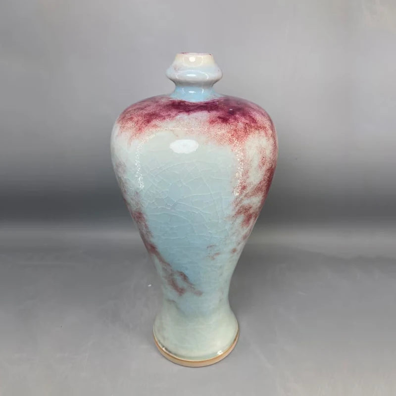 Un pot en céramique de couleur pastel avec des touches de rouge et de rose, créant un effet marbré élégant et unique.