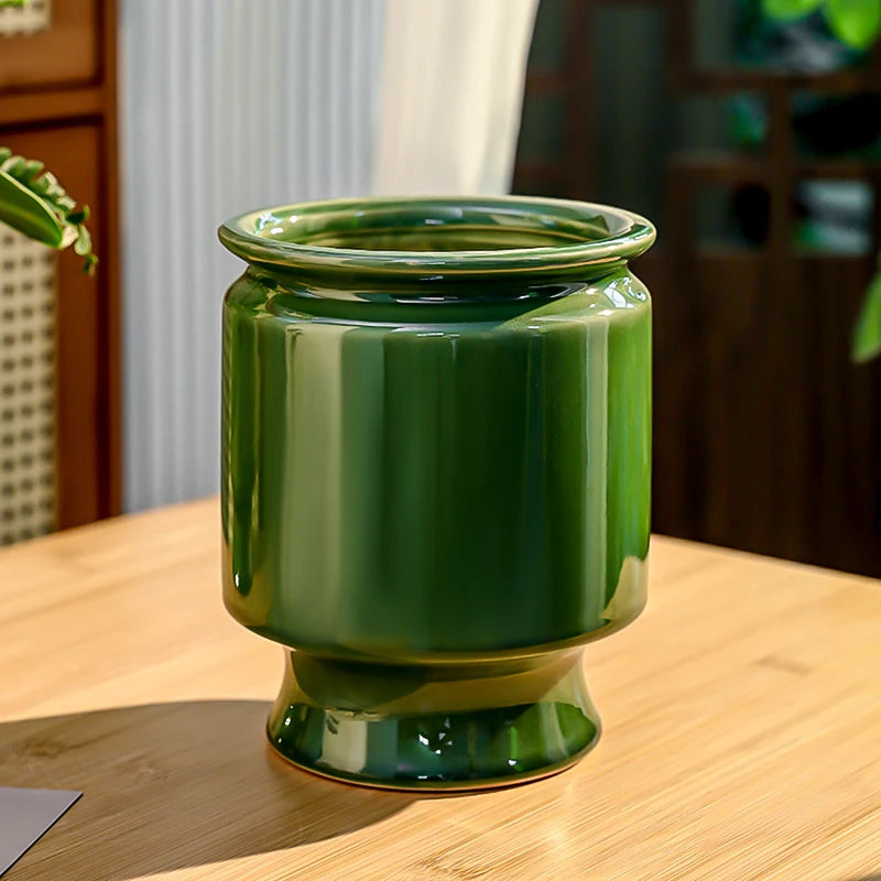 Un pot de verre vert brillant avec un aspect lustré, placé sur une surface en bois.