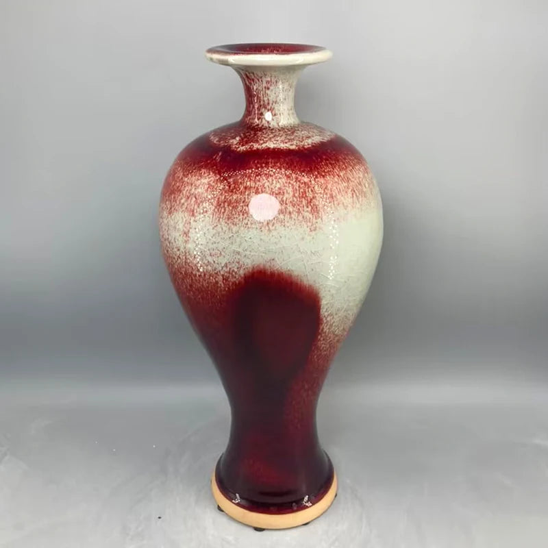 Vase en céramique de style vintage avec des touches de rouge et de blanc, présentant une texture et des motifs intéressants.